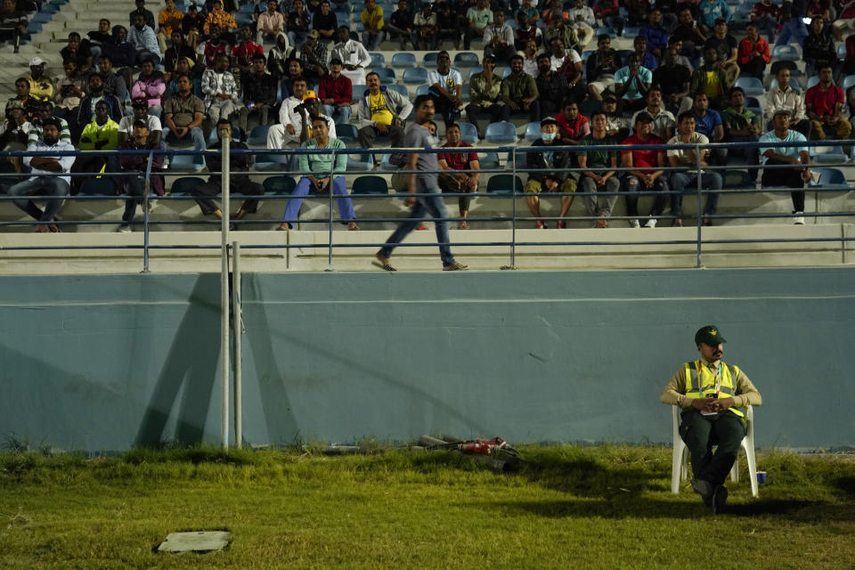 Laborers watch a World Cup match at a fan festival at the Asian Town cricket stadium in Doha, Qatar, Friday, Nov. 25, 2022. Far from the luxury hotels and sprawling new stadiums emblematic of Doha during the World Cup, scores of soccer-mad South Asian workers poured into a converted cricket stadium in the city's desert outskirts to enjoy the tournament they helped create. (AP Photo/Jon Gambrell)