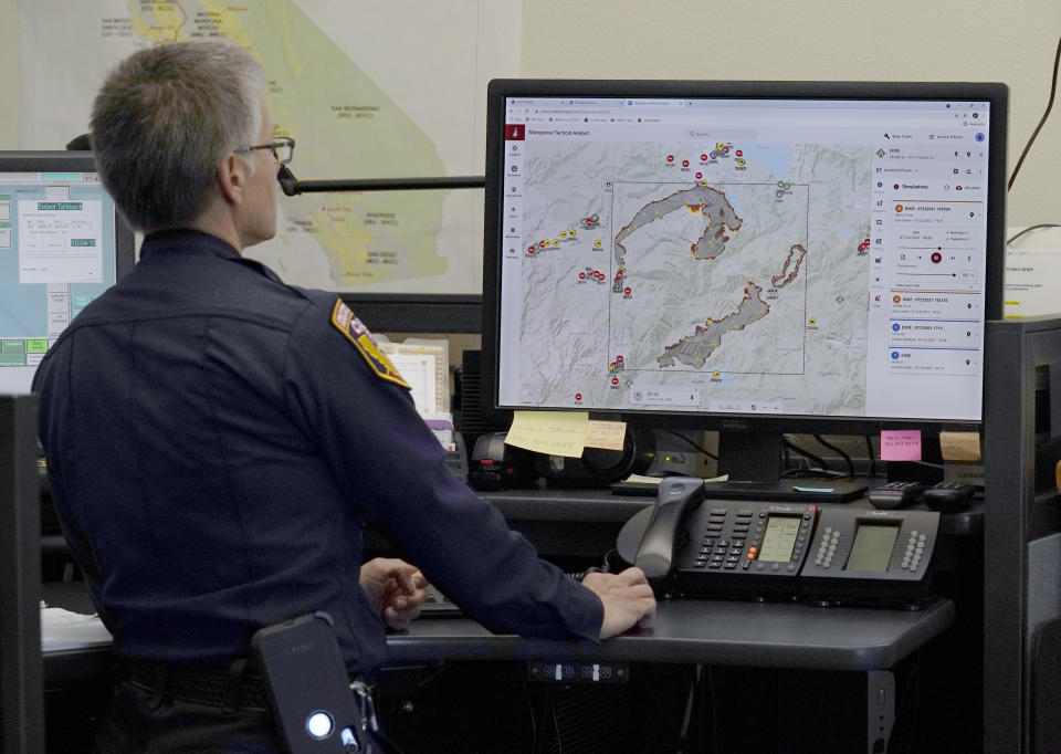 CORRECTS SPELLING OF FIRST NAME TO DANELL, NOT DANELLE - Cal Fire Capt. Danell Eshnaur uses the Fire Response Tactical Analyst program to use computer modeling to help pre-position fire fighting resources on the Dixie Fire at the California Department of Forestry and Fire Protection's Sacramento Command Center in Rancho Cordova, Calif., Friday, July 23, 2021. Firefighters are trying to become smarter in how they prepare for the drought- and wind-driven wildfires that have become more dangerous across the American West in recent years, including by using new technology like fire behavior computer modeling that can help assess risks before fires start, then project their path and growth. (AP Photo/Rich Pedroncelli)