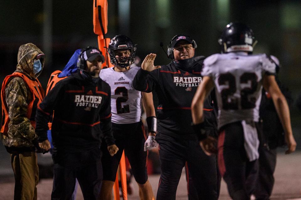 Southridge Head Coach Scott Buening and Kaleb Wibbeler (2) cheer on Southridge's Matt Springer (22) as he walks off the field during the IHSAA Class 3A Sectional 32 matchup at Memorial Stadium in Mount Vernon, Ind., Friday, Oct. 23, 2020. The Raiders defeated the Wildcats 42-10 to advance to the sectional semifinals. 