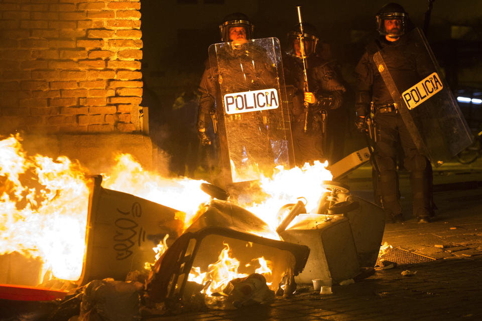 Los policías toman posiciones junto a una barricada antes de intervenir (AP).