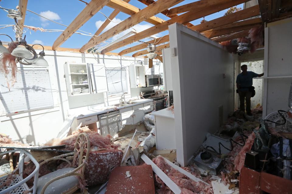 Insurance inspector Ryan Rhoades looks over the Mexico Beach home of the Redd family on Wednesday, Oct. 17, 2018, one week after Hurricane Michael tore the roof off and flooded the home as it ripped through the coastal Florida town. 