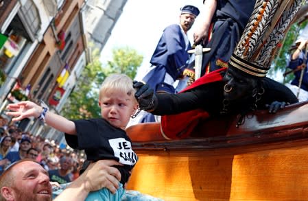 "The Savage", a white performer in a blackface disguise, touches a child during the festival Ducasse d'Ath in Ath