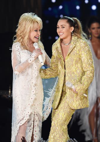 <p>Kevin Winter/Getty </p> Dolly Parton and Miley Cyrus in Los Angeles in February 2019