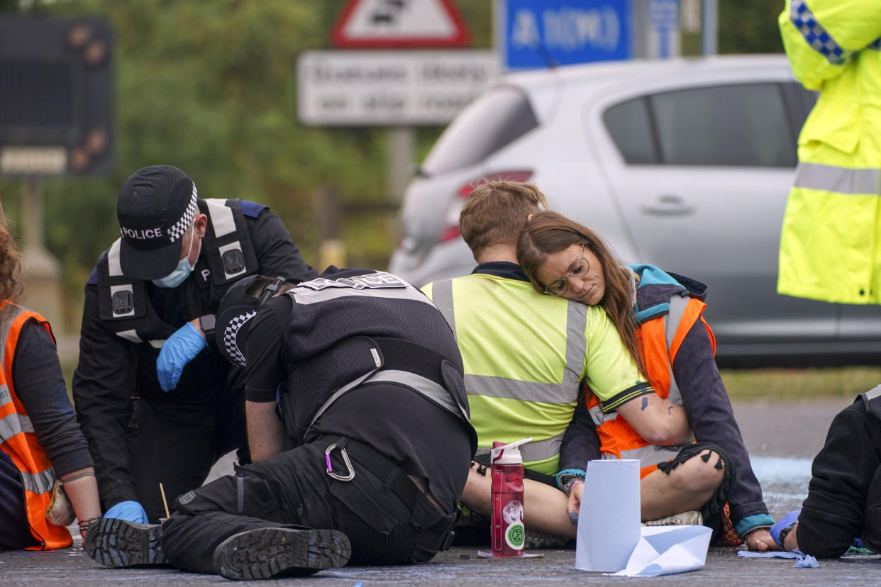 Police officers work to free protesters who had glued themselves to a slip road at Junction 4 of the A1(M), near Hatfield, where climate activists carried out a further action after demonstrations which took place last week across junctions in Kent, Essex, Hertfordshire and Surrey. Picture date: Monday September 20, 2021.