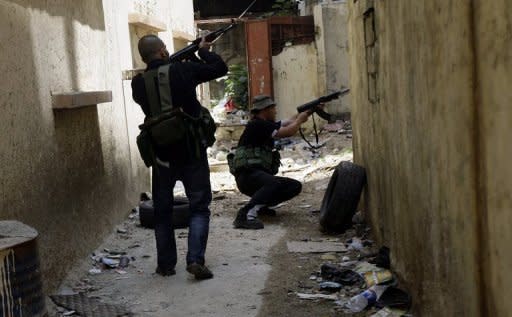 Lebanese Sunni Muslims gunmen are seen in the Bab al-Tebbaneh neighbourhood of the northern Lebanese city of Tripoli. Syrian troops have attacked a central rebel bastion, with dozens reportedly killed across the country, as the EU slaps fresh sanctions on Damascus