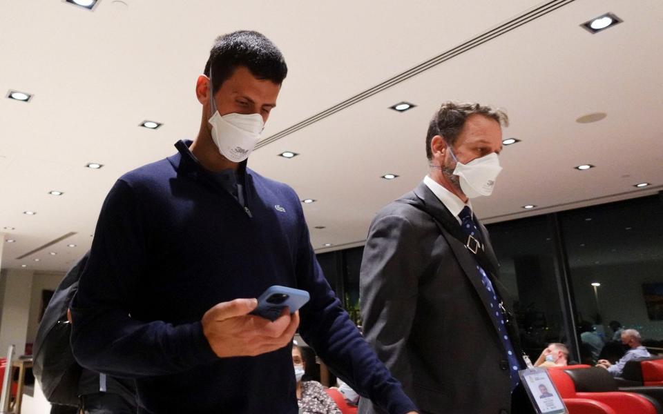 Novak Djokovic walks in Melbourne Airport before boarding a flight - REUTERS