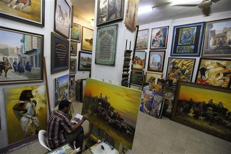Iraqi artist Ahmed al-Khazali paints in his workshop at a gallery in Baghdad's Karrada district, September 18, 2013. REUTERS/ Thaier Al-Sudani