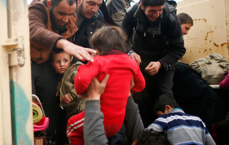 Displaced Iraqis help each other to get onto a truck to be carried to a safe place, as Iraqi forces battle with Islamic State militants, in western Mosul, Iraq March 8, 2017. REUTERS/Suhaib Salem TPX IMAGES OF THE DAY