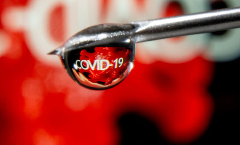 FILE PHOTO: FILE PHOTO: The word "COVID-19" is reflected in a drop on a syringe needle in this illustration