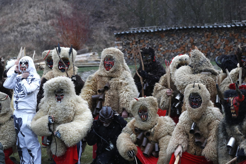 Revelers depicting grim reapers and devils pose for a photo during a traditional St Nicholas procession in the village of Valasska Polanka, Czech Republic, Saturday, Dec. 7, 2019. This pre-Christmas tradition has survived for centuries in a few villages in the eastern part of the country. The whole group parades through village for the weekend, going from door to door. St.Nicholas presents the kids with sweets. The devils wearing home made masks of sheep skin and the white creatures representing death with scythes frighten them. (AP Photo/Petr David Josek)