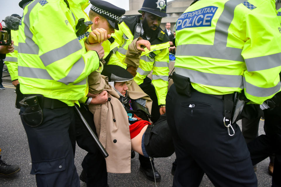 Police officers remove protesters from a blockade on Waterloo Bridge during the second day of a coordinated protest by the Extinction Rebellion group, London on April 16, 2019. More than 100 arrests have been made, with demonstrations blocking a number of locations across the capital. (Photo by Alberto Pezzali/NurPhoto via Getty Images)