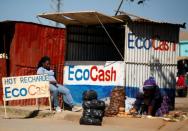 A street vendor awaits customers outside a stall at a marketplace in Chitungwiza