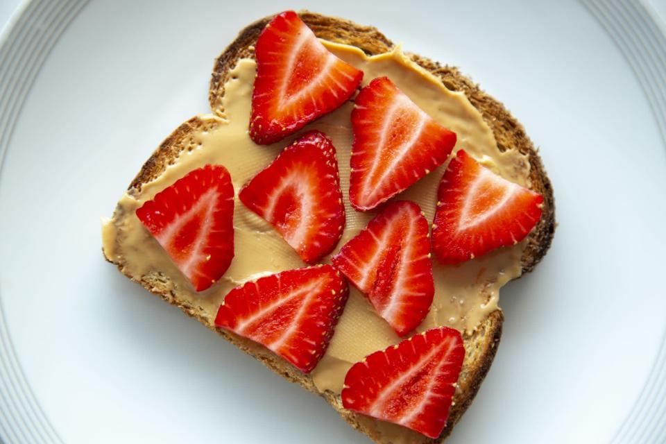 An easy breakfast of peanut butter and strawberries on toast.