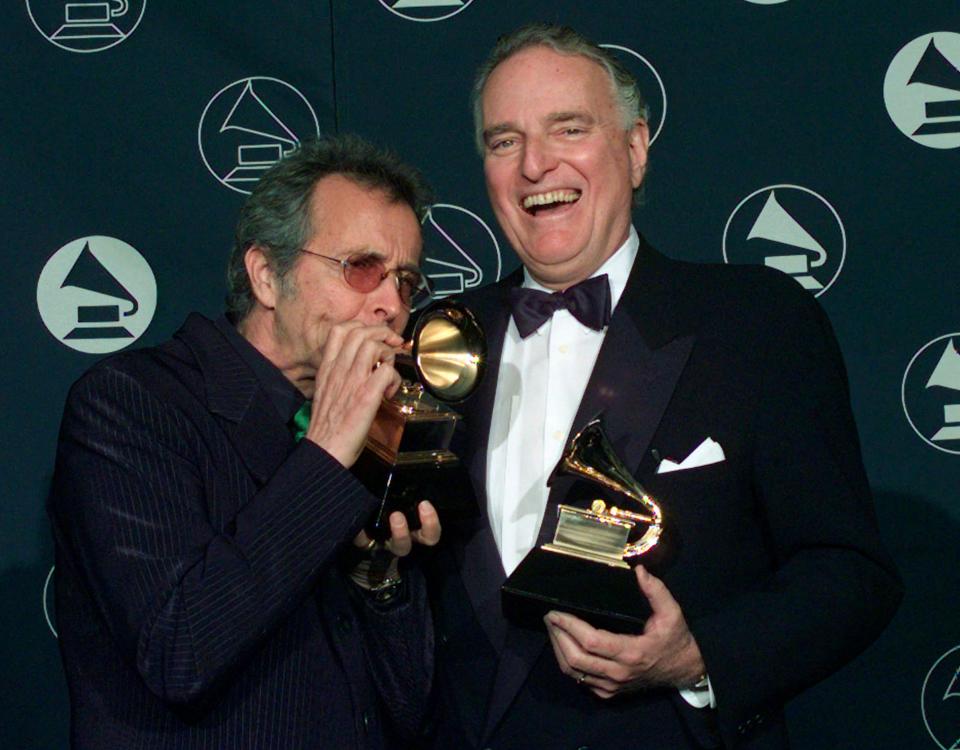 Herb Alpert, left, makes a trumpet of his Grammy award alongside Jerry Moss, as the two hold their Trustee Awards during the 39th Annual Grammy Awards in New York on Feb. 26, 1997.