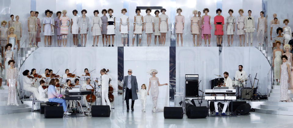 German fashion designer Karl Lagerfeld, center left, holds the hand of Hudson Kroenig, 5, while model Cara Delevingne wears the wedding gown during Chanel's Spring-Summer 2014 Haute Couture fashion collection presented in Paris, Tuesday, Jan.21, 2014. (AP Photo/Jacques Brinon)