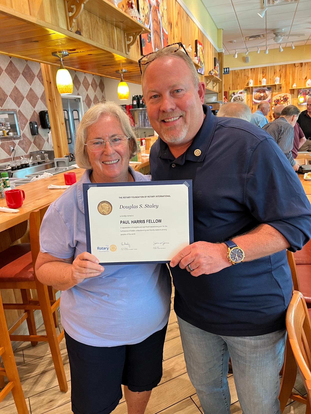 Douglas Staley accepts the Paul Harris Fellow Award from Sue McConnell, president of the Rotary Club of Gulf Gate.