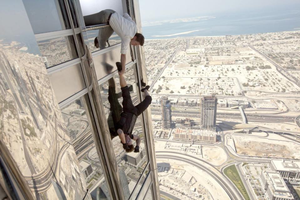 benji dunn hangs on to ethan hunt, who dangles out the window high up in the burj khalifa, in a scene from mission impossible ghost protocol it is the fourth film if you're watching the mission impossible movies in order