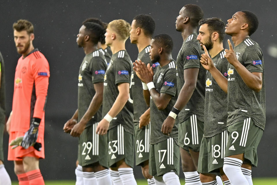 Manchester United players line up prior to the start of an Europa League semifinal match between Sevilla and Manchester United, in Cologne, Germany, Sunday, Aug. 16, 2020. (AP Photo/Martin Meissner, Pool)