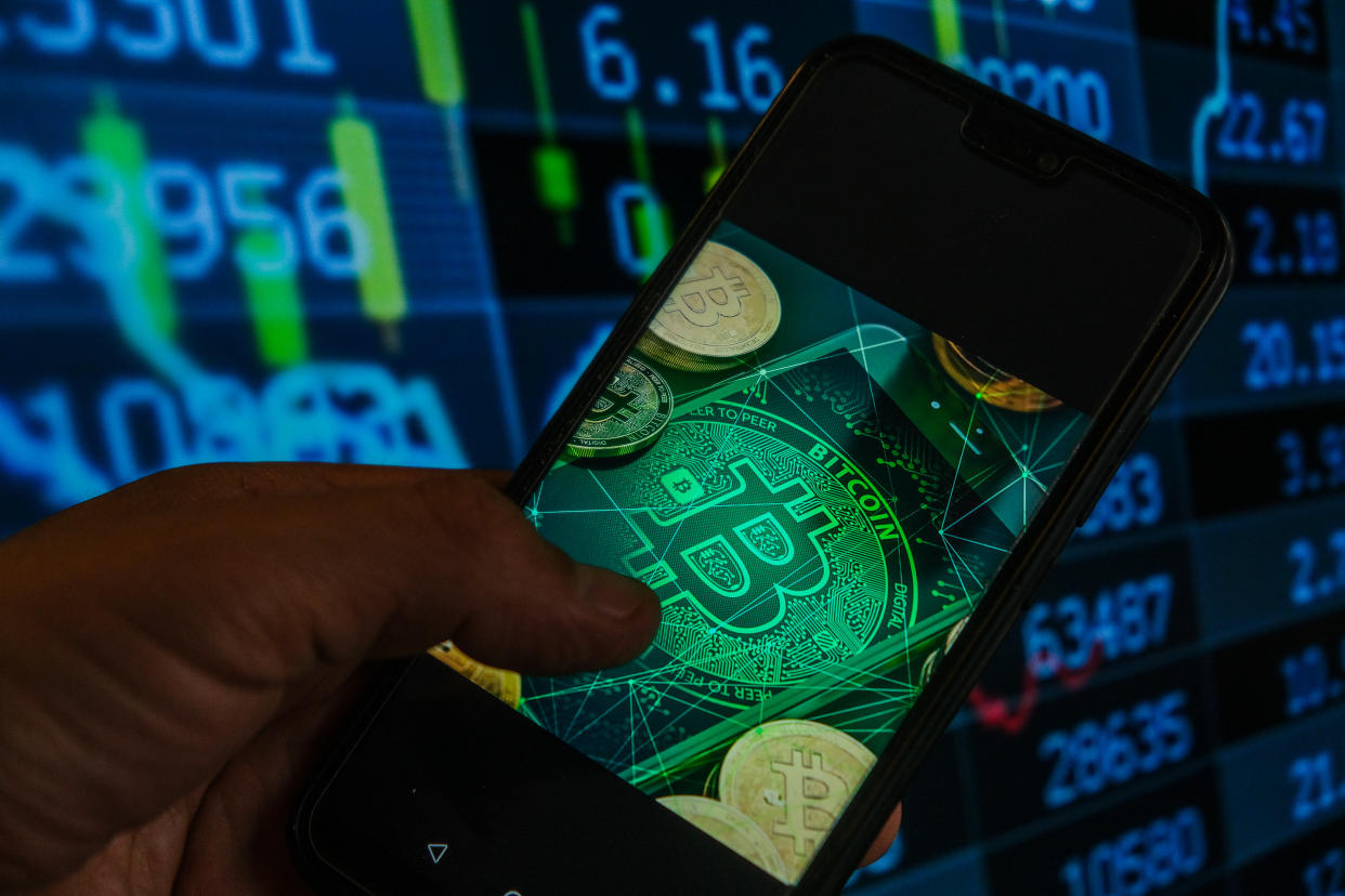 POLAND - 2021/05/18: In this photo illustration a Bitcoin logo seen displayed on a smartphone with stock market percentages in the background. (Photo Illustration by Omar Marques/SOPA Images/LightRocket via Getty Images)