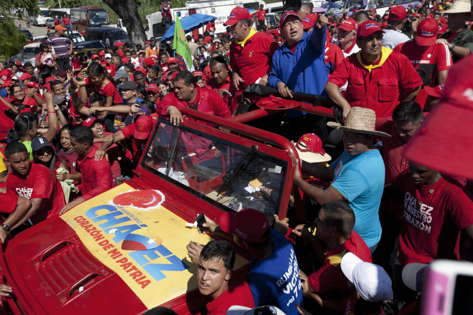 Venezuela's President Hugo Chavez greets supporters from the top of a vehicle during a campaign caravan from Barinas to Caracas, in Sabaneta, Venezuela, Monday, Oct. 1, 2012. Venezuela's presidential election is scheduled for Oct. 7. (AP Photo/Rodrigo Abd)
