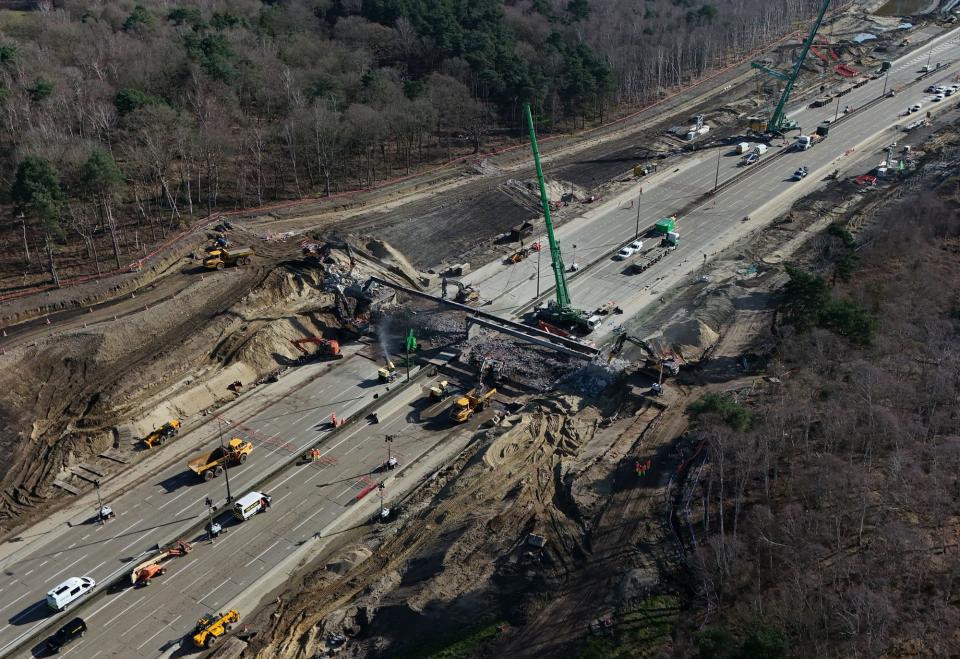 Workman on the section of the M25 between Junctions 10 and 11, in Surrey, that is closed in both directions while a bridge is demolished and a new gantry is installed (Yui Mok/PA Wire)