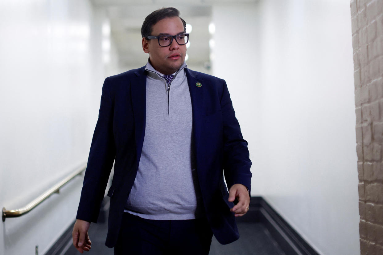 Rep. George Santos, R-N.Y., walks down a hallway.