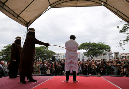 FILE PHOTO: An Indonesian man is publicly caned for having gay sex in Banda Aceh, Aceh province, Indonesia May 23, 2017. Picture taken May 23, 2017. REUTERS/Beawiharta/File Photo