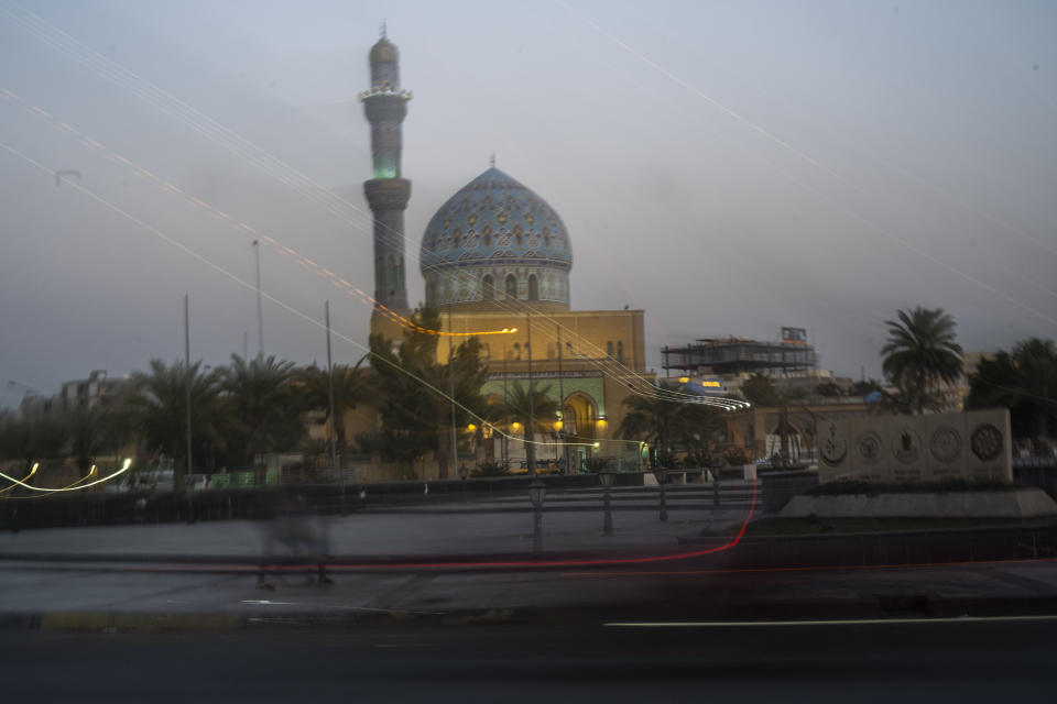 In a long exposure photo, night sets on Firdos Square, the site where American soldiers downed a statue of Saddam Hussein two decades earlier in Baghdad, Iraq, Tuesday, Feb. 28, 2023. Today's Iraq is a world away from the terror that followed the U.S. invasion to depose Saddam Hussein. (AP Photo/Jerome Delay)