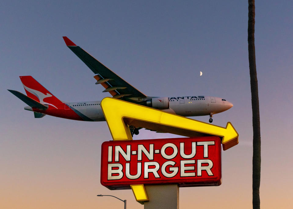 a plane flying over In-N-Out Burger