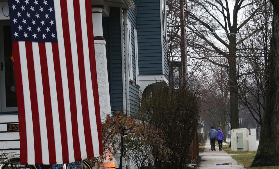 In this March 19, 2020, photo, a family takes a walk in Oak Park, Ill., before a two-week "shelter in place" order goes into effect. Leaders in the Chicago suburb were the first in the state to take the step, requiring non-essential businesses to close, to try to curb the spread of the coronavirus. (AP Photo/Martha Irvine)