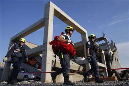 Rescue specialists for USA-1 leave the scene of a mock disaster area during a training exercise at the Guardian Center in Perry, Georgia, March 24, 2014. REUTERS/Shannon Stapleton