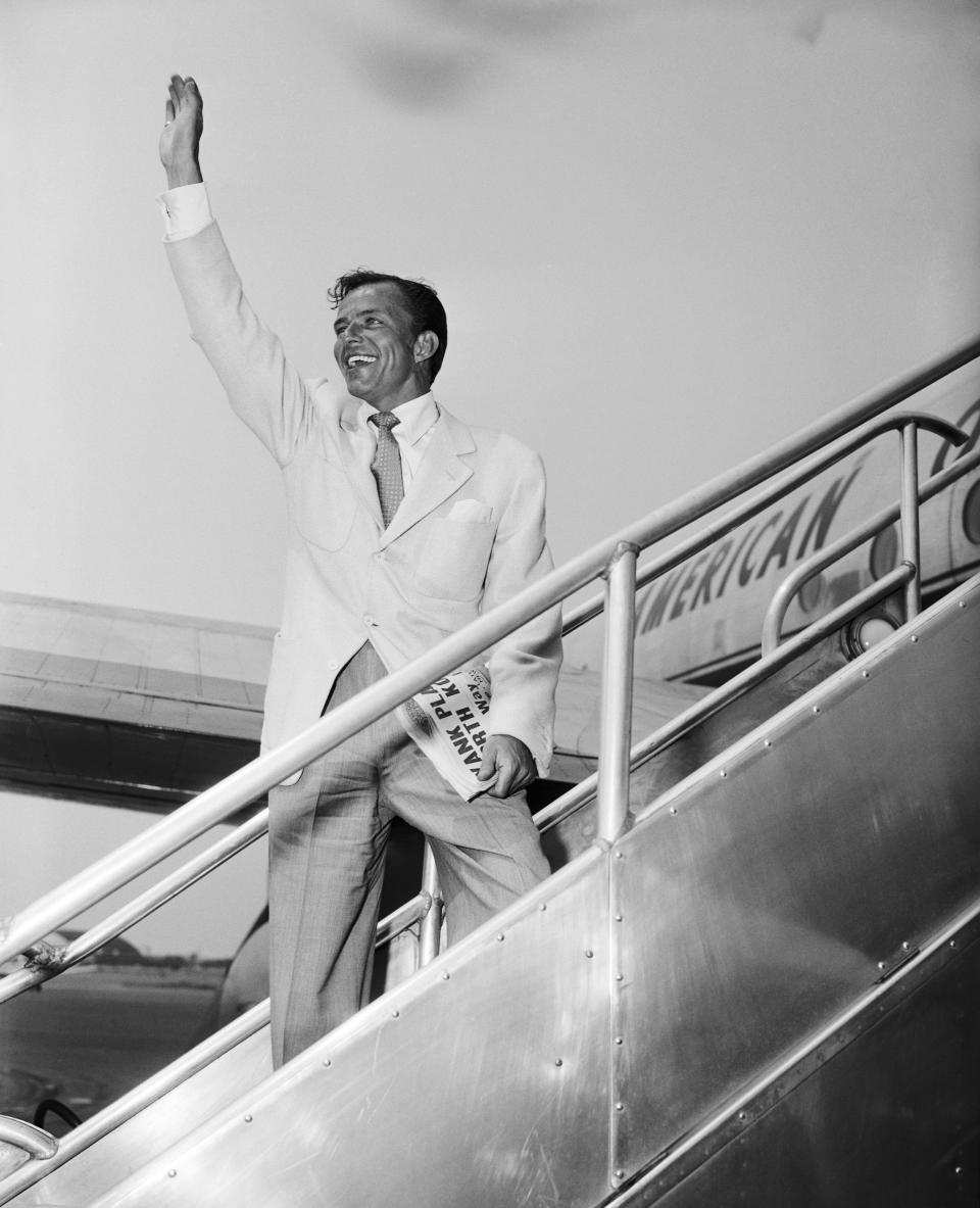 Frank Sinatra waving goodbye at Idlewild Airport, just before leaving for London via American Overseas Airlines; 06/30/1950, Queens, New York