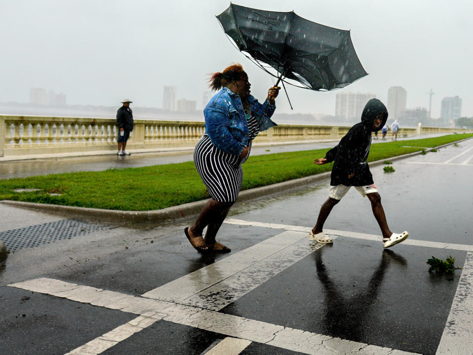 <p>A woman holds tight to her inverted umbrella in Tampa on Sept. 28.</p>