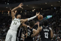 Milwaukee Bucks' Giannis Antetokounmpo (34) reaches for a rebound during the first half of the team's NBA basketball game against the Brooklyn Nets, Tuesday, Oct. 19, 2021, in Milwaukee. (AP Photo/Morry Gash)