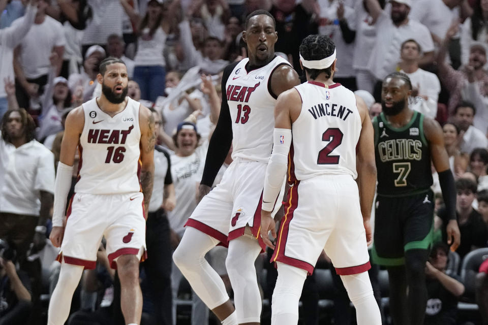 Miami Heat center Bam Adebayo (13) reacts guard Gabe Vincent (2) three-point shot during the second half of Game 3 of the NBA basketball playoffs Eastern Conference finals against the Boston Celtics, Sunday, May 21, 2023, in Miami. (AP Photo/Wilfredo Lee)