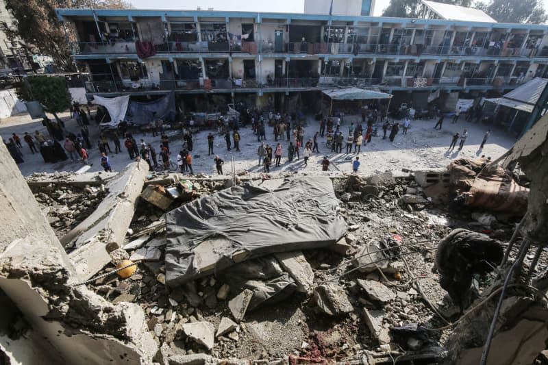 Palestinians inspect damages after an Israeli airstrike on a school for displaced people run by the United Nations Relief and Works Agency for Palestine Refugees in the Near East (UNRWA) in Nuseirat refugee camp in the middle of the Gaza Strip. Omar Naaman/dpa