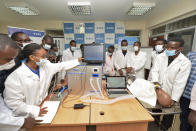 FILE - In this Monday, April 13, 2020 file photo, medical students test a self-designed computer-controlled ventilator prototype at the Chandaria Business and Incubation Centre of Kenyatta University in Nairobi, Kenya. More than two dozen international aid organizations have told the U.S. government they are "increasingly alarmed" that "little to no U.S. humanitarian assistance has reached those on the front lines" of the coronavirus pandemic as the number of new cases picks up speed in some of the world's most fragile regions. (AP Photo/John Muchucha, File)