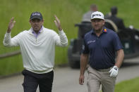 Charles Schwartzel of South Africa, gestures as he walks with Graeme McDowell of Northern Ireland during the first round of the inaugural LIV Golf Invitational at the Centurion Club in St Albans, England, Thursday, June 9, 2022. (AP Photo/Alastair Grant)