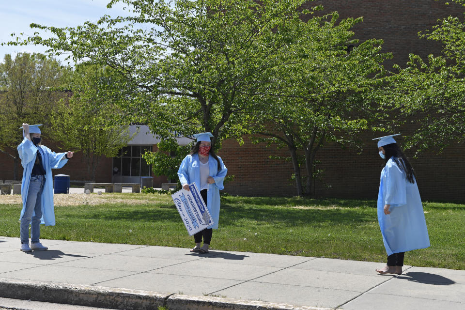 South River High School Class of 2020 seniors, from left, Jocelyn Fillius, 18, of Churchton, Md., Claire Twomey, 17, and Charmi Patel, 18, both of Crofton, Md., say hello as they socially distance before the start of a community-organized car parade that began in the school parking lot in Edgewater, Md., Saturday, April 25, 2020. Many of the South River High School families found ways to celebrate their seniors given that prom, graduation and other traditional senior activities were canceled because of the coronavirus pandemic. (AP Photo/Susan Walsh)