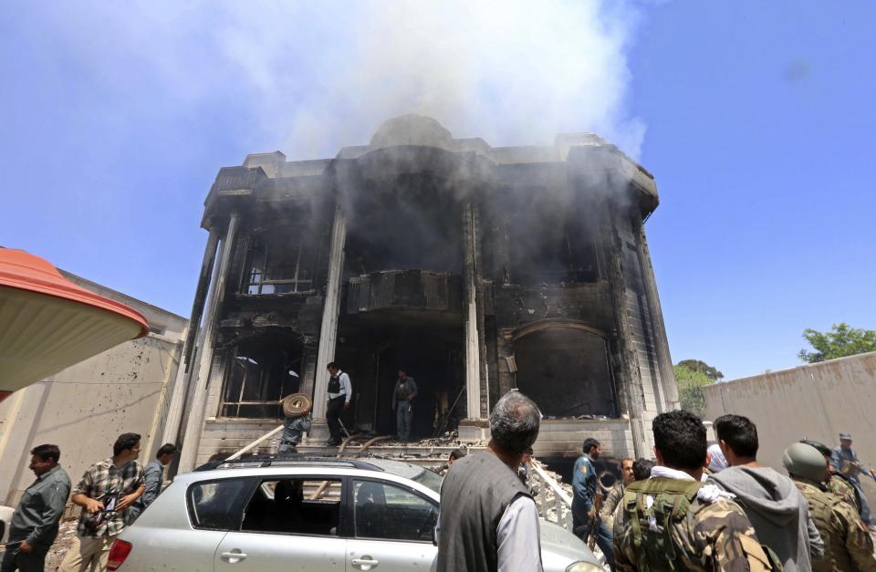 Afghan security officers investigate near smoke rising from a residential building, where insurgents were holed up in, after an attack on the Indian consulate in Herat province May 23, 2014. (REUTERS/Mohammad Shoib)