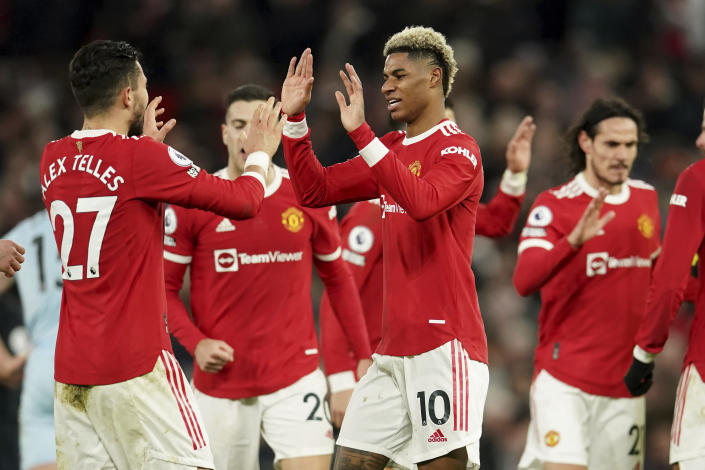 Manchester United's Marcus Rashford, center, celebrates with teammates after scoring his side's first goal during the English Premier League soccer match between Manchester United and West Ham at Old Trafford stadium in Manchester, England, Saturday, Jan. 22, 2022. (AP Photo/Dave Thompson)