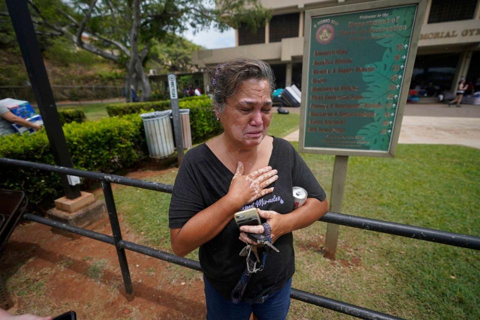 PHOTO: Myrna Ah Hee waits in front of an evacuation center at the War Memorial Gymnasium, Aug. 10, 2023, while looking for her husband's brother, in Wailuku, Hawaii. (Rick Bowmer/AP)