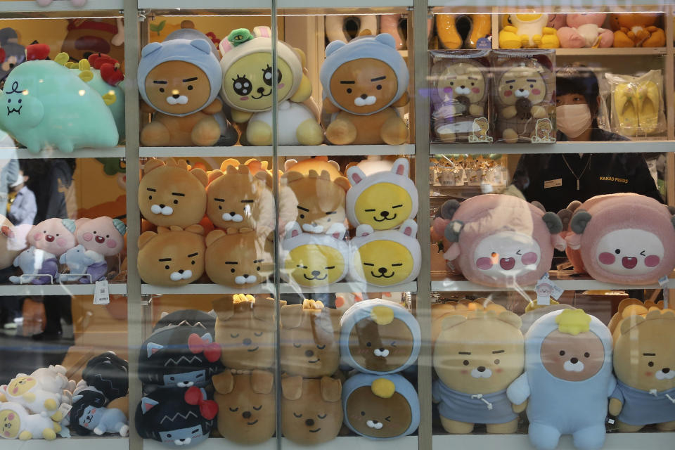 An employee wearing a face mask to help protect against the spread of the coronavirus arranges dolls at a shop in Seoul, South Korea, Thursday, Oct. 22, 2020. The steady spread of the coronavirus caused concern in a country that eased its social distancing restrictions just last week to cope with a weak economy. (AP Photo/Ahn Young-joon)