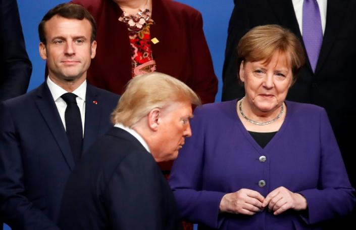 France's President Emmanuel Macron and Germany's Chancellor Angela Merkel look as US President Donald Trump walks past them during a family photo as part of the NATO summit in London in December 2019 (AFP Photo/CHRISTIAN HARTMANN)