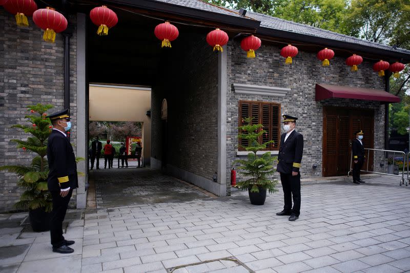 Security guards wearing masks stand guard at an entrance in the Tanhualin neighborhood after the lockdown was lifted in Wuhan