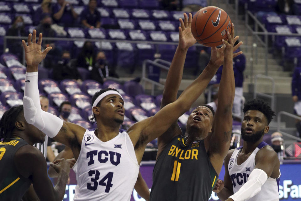 TCU forward Kevin Easley (34) and Baylor guard Mark Vital (11) try to grab a rebound in the second half of an NCAA college basketball game, Saturday, Jan. 9, 2021, in Fort Worth, Texas. (AP Photo/ Richard W. Rodriguez)