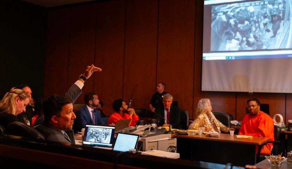 Prosecutor Brad Ng, left, questions a cousin of mass shooting victim Sergio Harris during a preliminary hearing in Sacramento Superior Court on Tuesday in the case of the April 2022 mass shooting in downtown Sacramento. Ng’s questions involved video evidence depicting events from the night of the shooting that was projected in the courtroom.