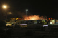 In this photo released by the Syrian official news agency SANA, shows flames rising from the scene of missiles attack, at the seaport of the coastal city of Latakia, Syria, Tuesday, Dec. 7, 2021. Syria's military said Israeli warplanes fired the missiles causing fire without inflicting any human losses. Syria's state media quoted an unnamed military official as saying that several missiles struck the containers area in the port early on Tuesday, setting some of them on fire. (SANA via AP)