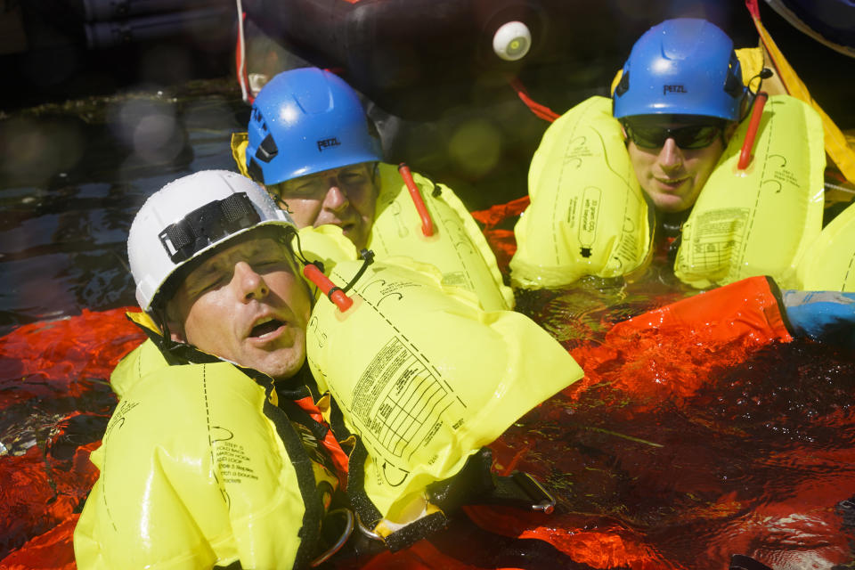 Instructor Pete Nagorka, left, demonstrates how to keep an injured person afloat during a Global Wind Organisation certification class at the Massachusetts Maritime Academy in Bourne, Mass., Thursday, Aug. 4, 2022. At the 131-year-old maritime academy along Buzzards Bay, people who will build the nation's first commercial-scale offshore wind farm are learning the skills to stay safe while working around turbines at sea. (AP Photo/Seth Wenig)