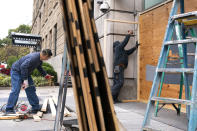 Ahead of the presidential election, workers board up Brown Bag, a restaurant on I Street NW, Friday, Oct. 30, 2020, near the White House in downtown Washington. (AP Photo/Jacquelyn Martin)